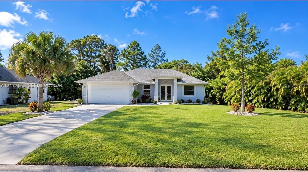 Single-story exterior featuring a light-toned stucco facade, a concrete driveway, a two-car garage, and double-entry doors sheltered by a portico Single-story exterior featuring a light-toned stucco facade, a concrete driveway, a two-car garage, and double-entry doors sheltered by a portico