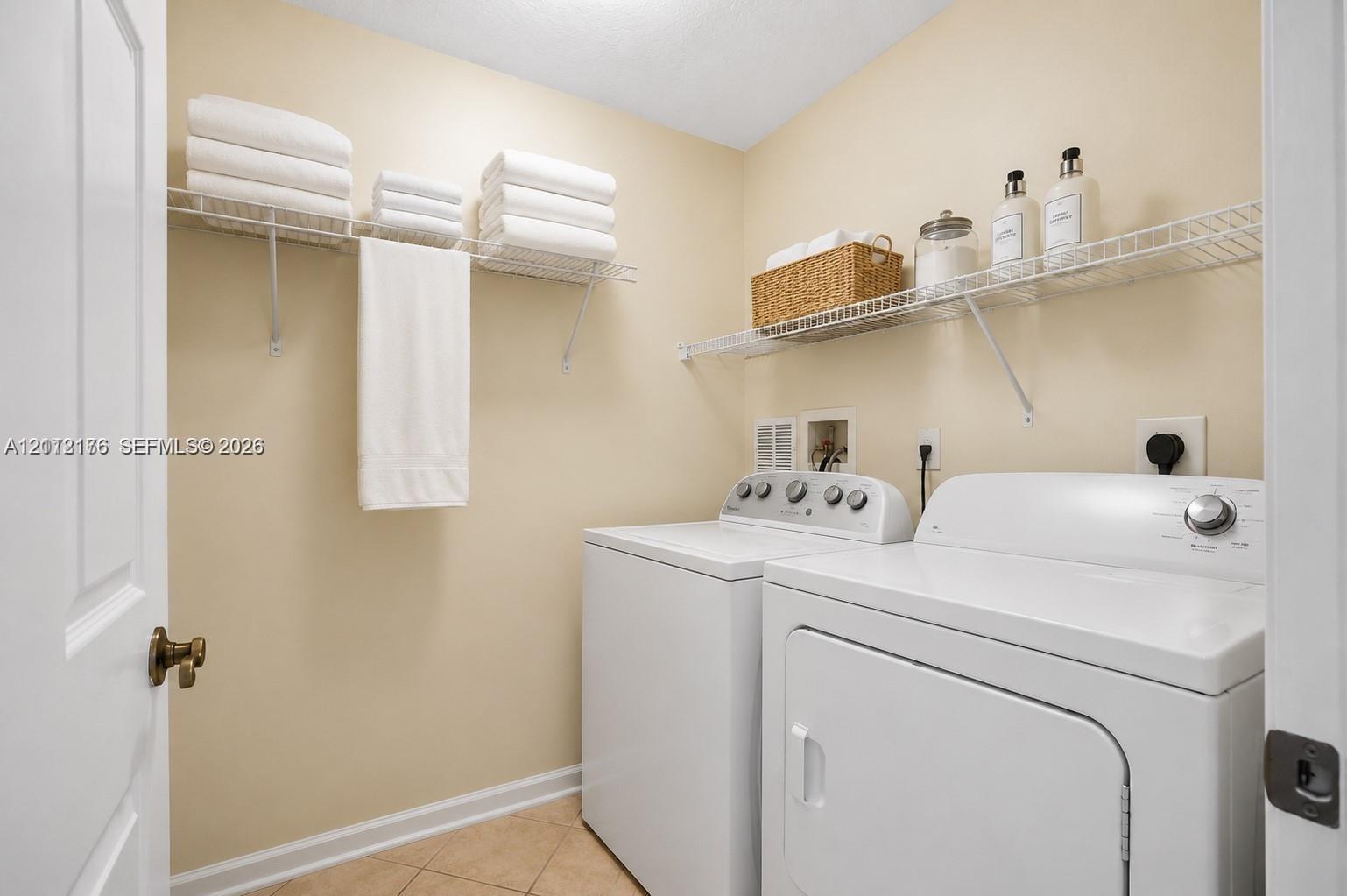 Laundry area featuring tile flooring and multi-level wire shelving Laundry area featuring tile flooring and multi-level wire shelving