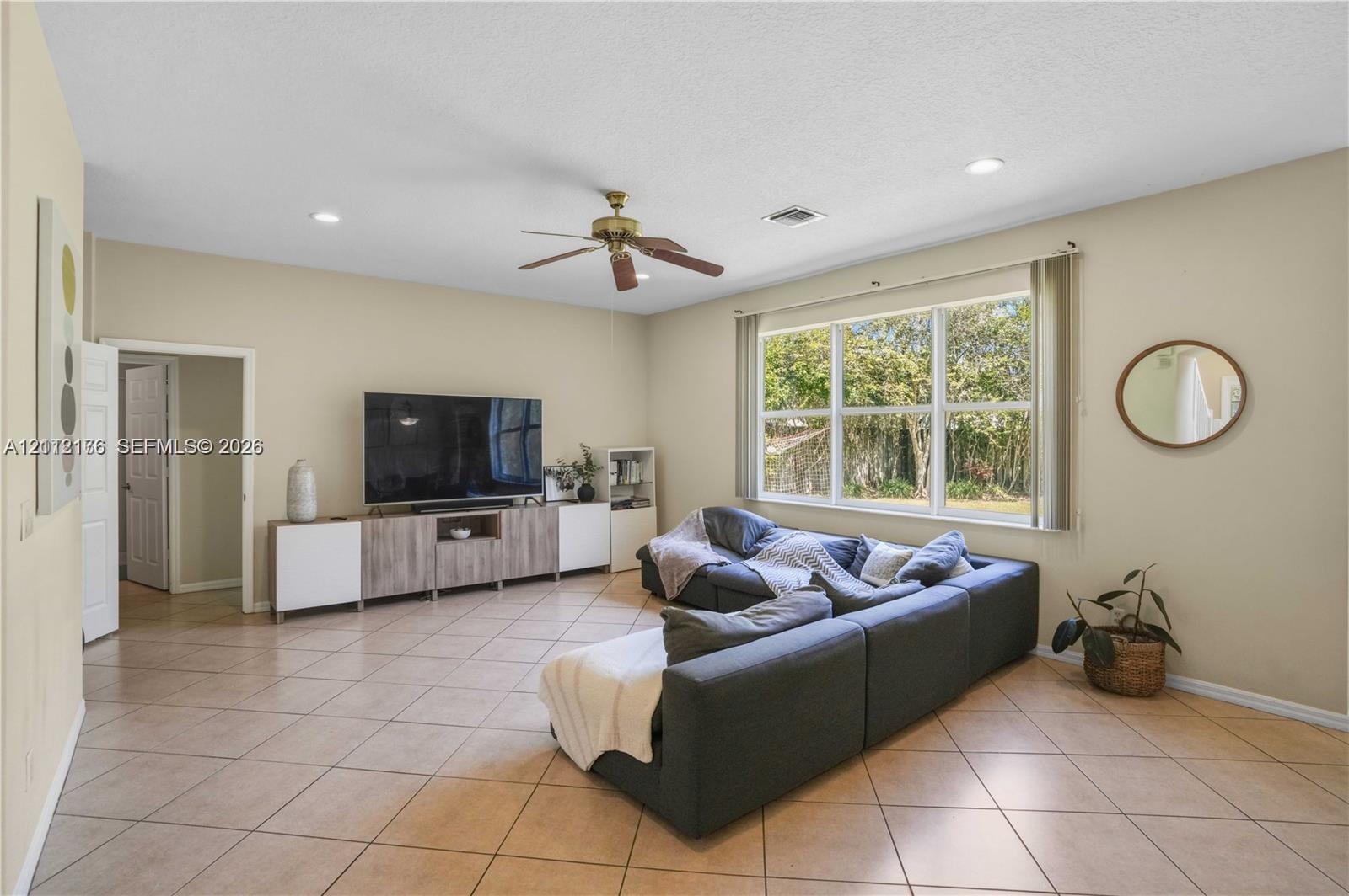 Living area featuring large format diagonal tile flooring, recessed lighting, a ceiling fan, and expansive windows