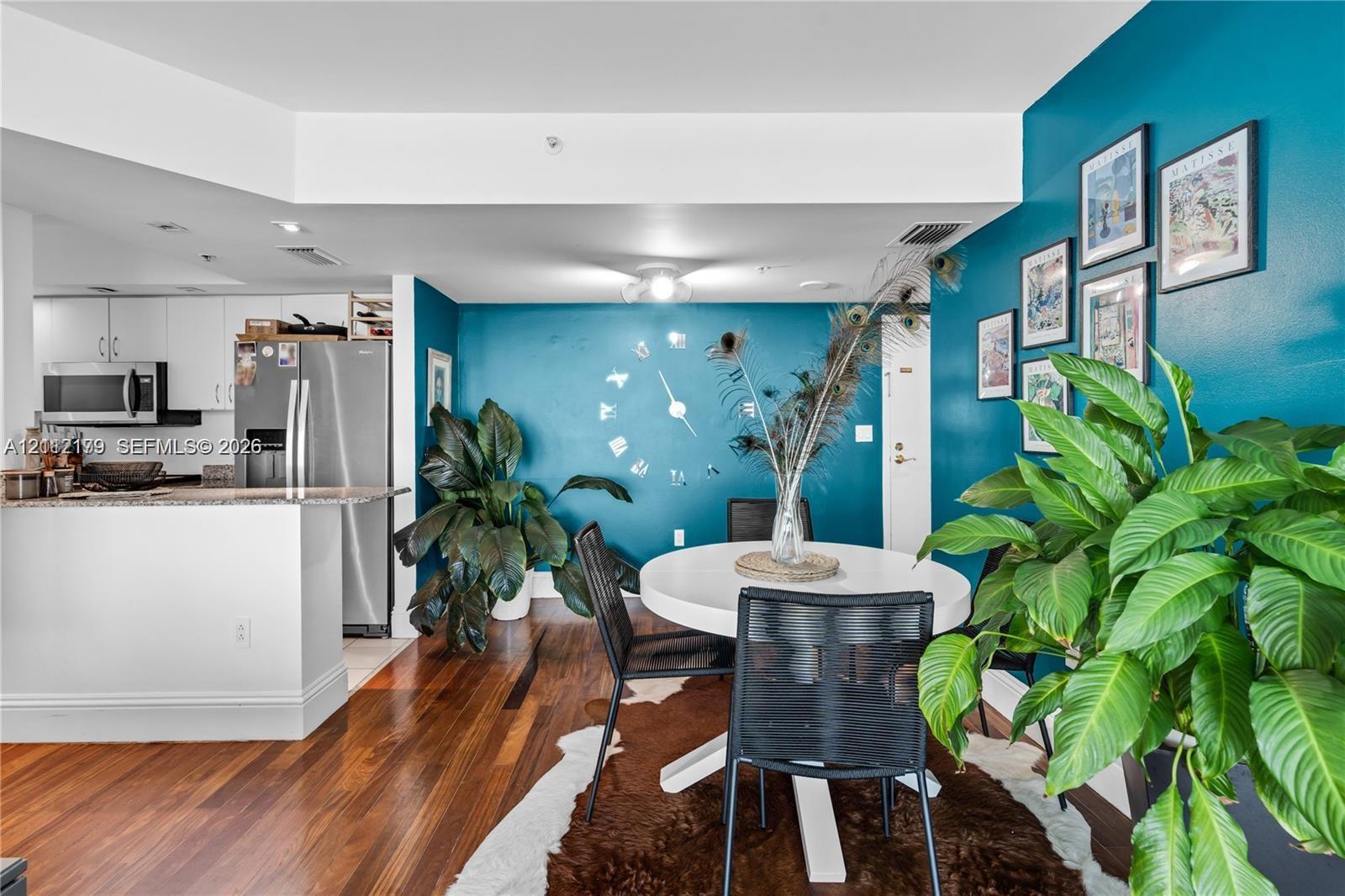Open-concept kitchen featuring stainless steel appliances and a peninsula counter, set against wood-finish flooring