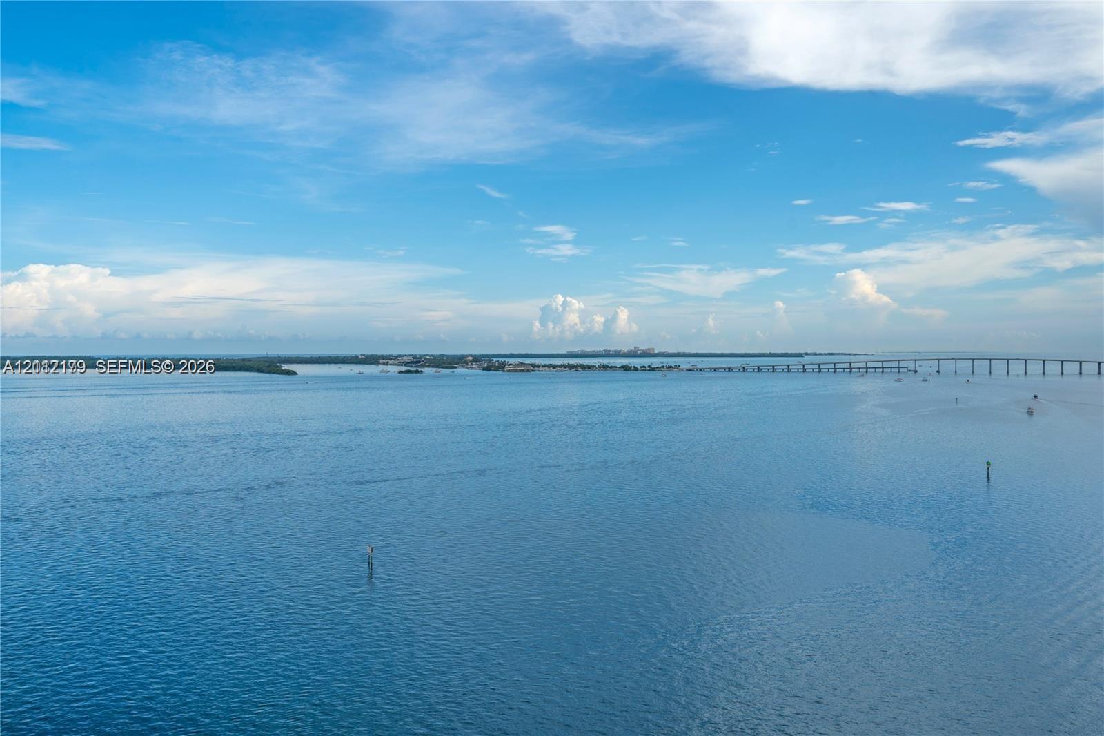 Expansive open-water scenery featuring a bridge and a distant shoreline