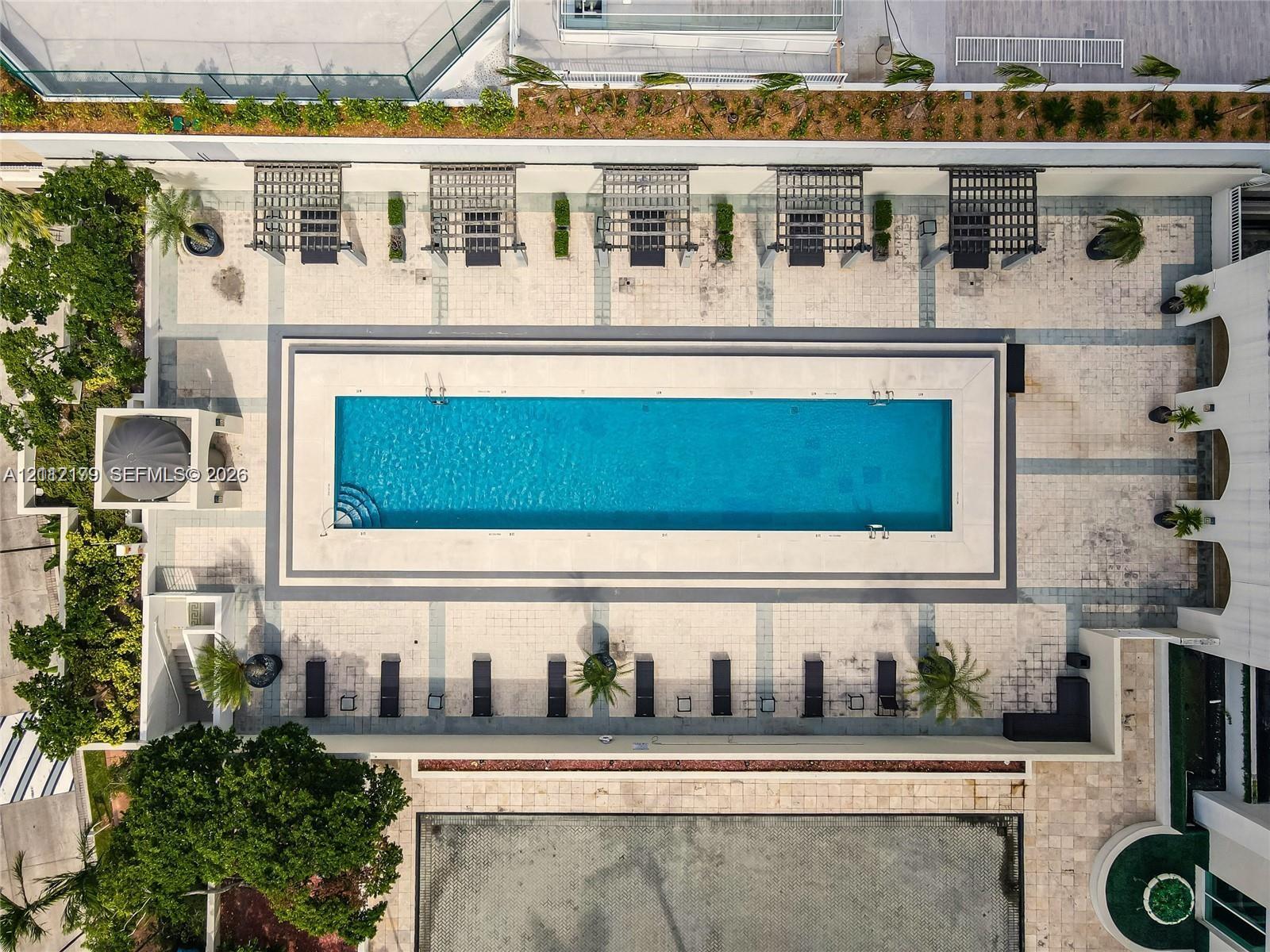 Rectangular lap pool featuring stone decking, multiple built-in pergola structures, integrated landscaping, and a tiered patio surround