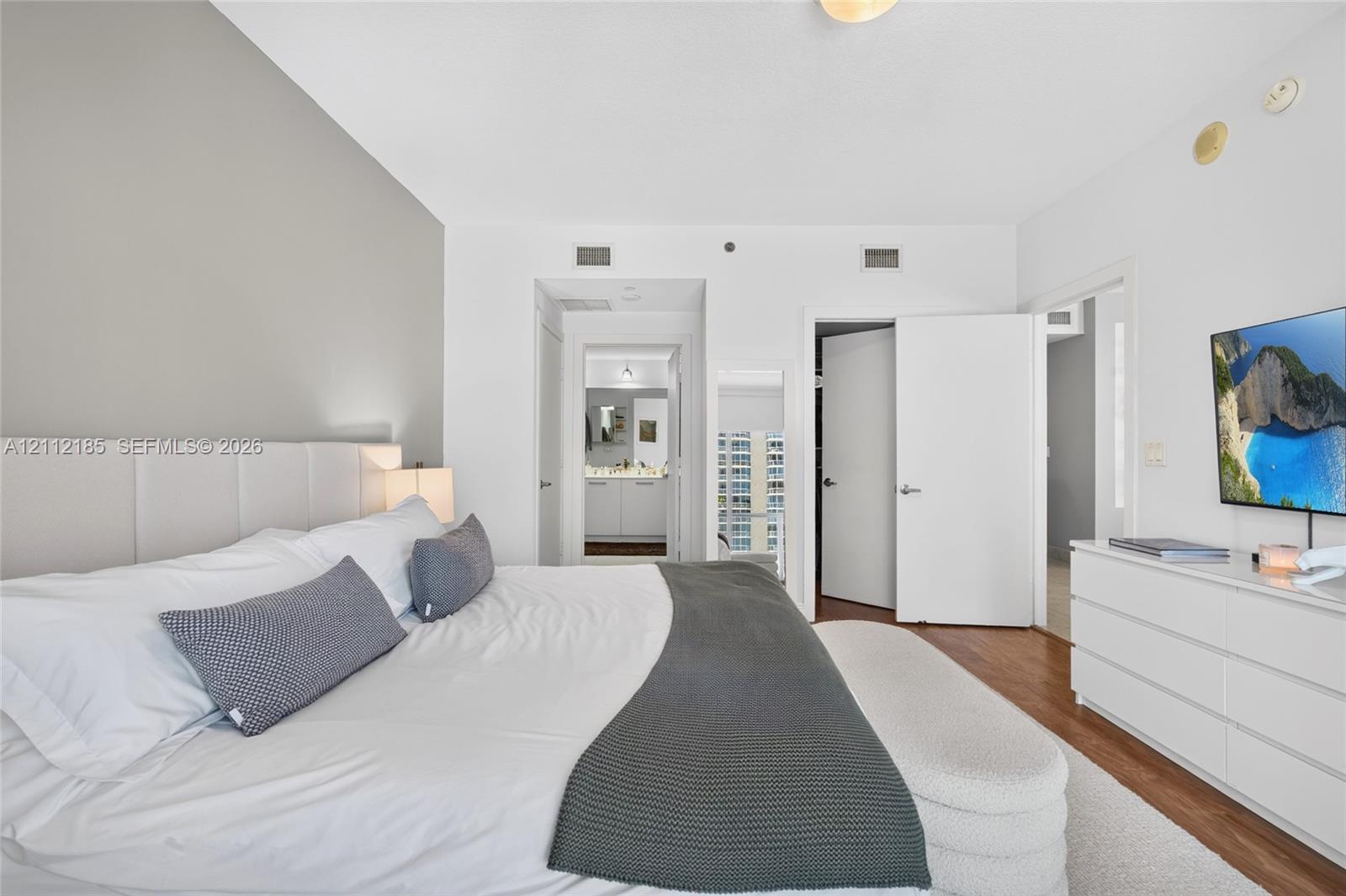Neutral interior featuring wood-finish flooring, a charcoal gray accent wall, and solid-core interior doors