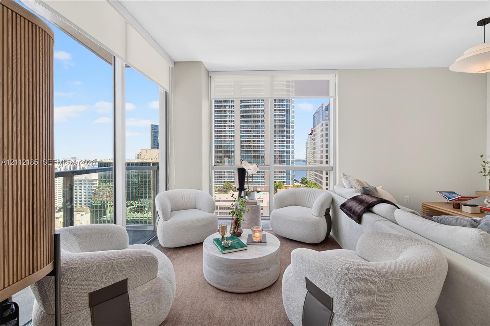 Floor-to-ceiling windows, motorized solar shades, recessed lighting, and a pendant light fixture