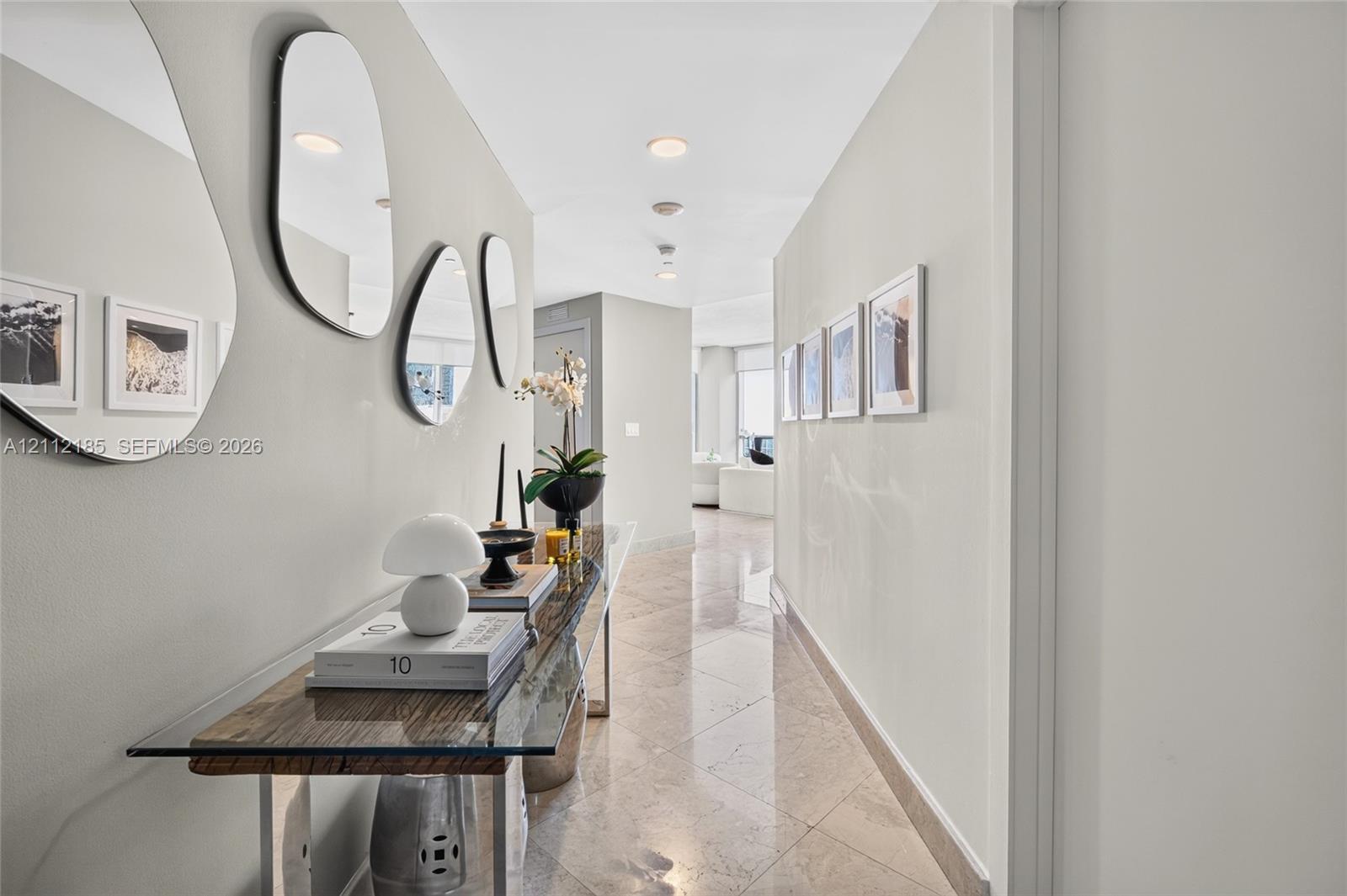 Interior hallway featuring polished stone flooring, recessed ceiling lighting, and neutral-toned wall paint