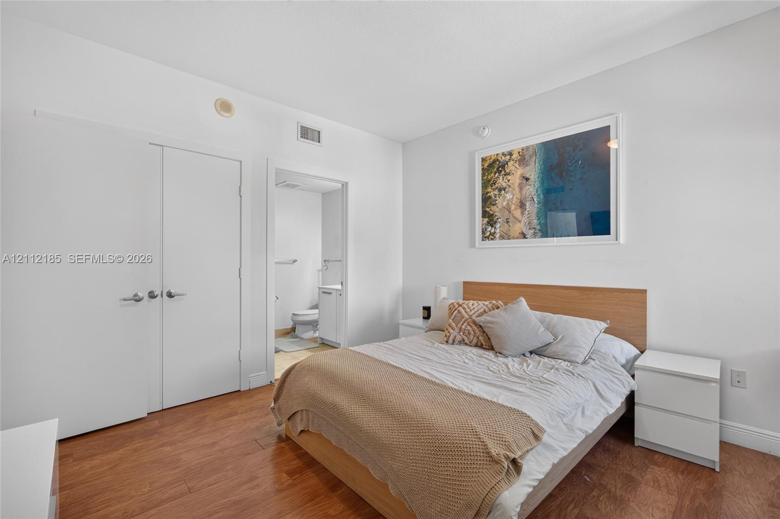 Wood-finish flooring and double-door closet with brushed nickel hardware