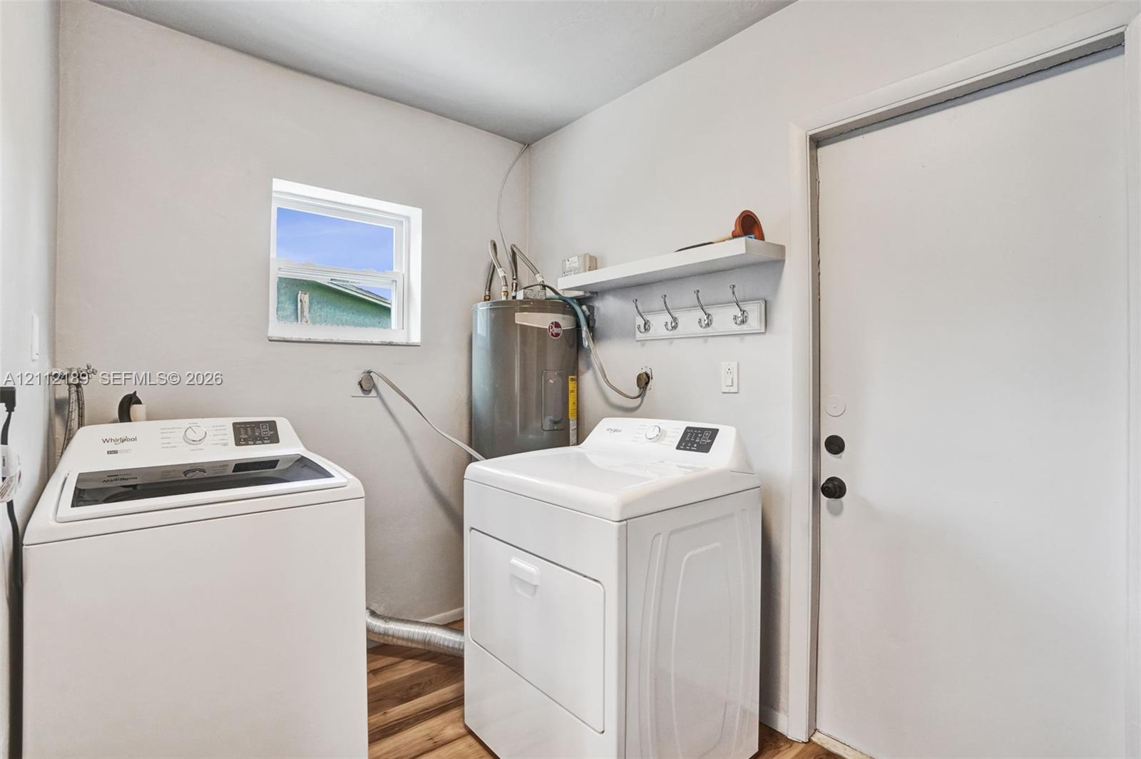 Utility space featuring wood-finish flooring, a wall-mounted shelf with integrated hooks, and a dedicated window