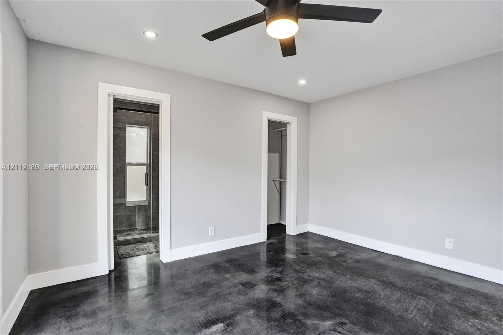 Polished concrete flooring, recessed lighting, and a modern ceiling fan with integrated lighting