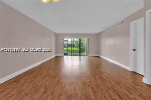 Neutral wall color, wood-finish flooring, and sliding glass doors with exterior access Neutral wall color, wood-finish flooring, and sliding glass doors with exterior access