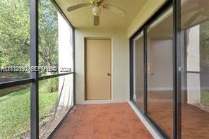 Screen-enclosed patio featuring tile flooring, a ceiling-mounted fan, and glass sliding doors Screen-enclosed patio featuring tile flooring, a ceiling-mounted fan, and glass sliding doors
