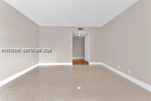 Neutral interior space featuring polished tile flooring, light-toned walls, and recessed ceiling lighting