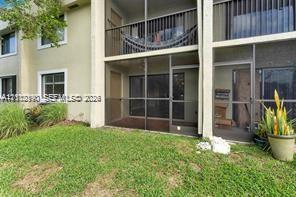 Multi-level exterior featuring screened-in patios, dark-framed sliding glass doors, horizontal metal railings, and stucco siding