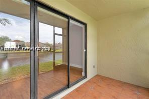 Covered patio featuring ceramic tile flooring, textured wall finishes, and large sliding glass doors