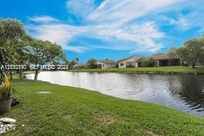 Waterfront property featuring a canal, expansive lawn, and mature trees Waterfront property featuring a canal, expansive lawn, and mature trees