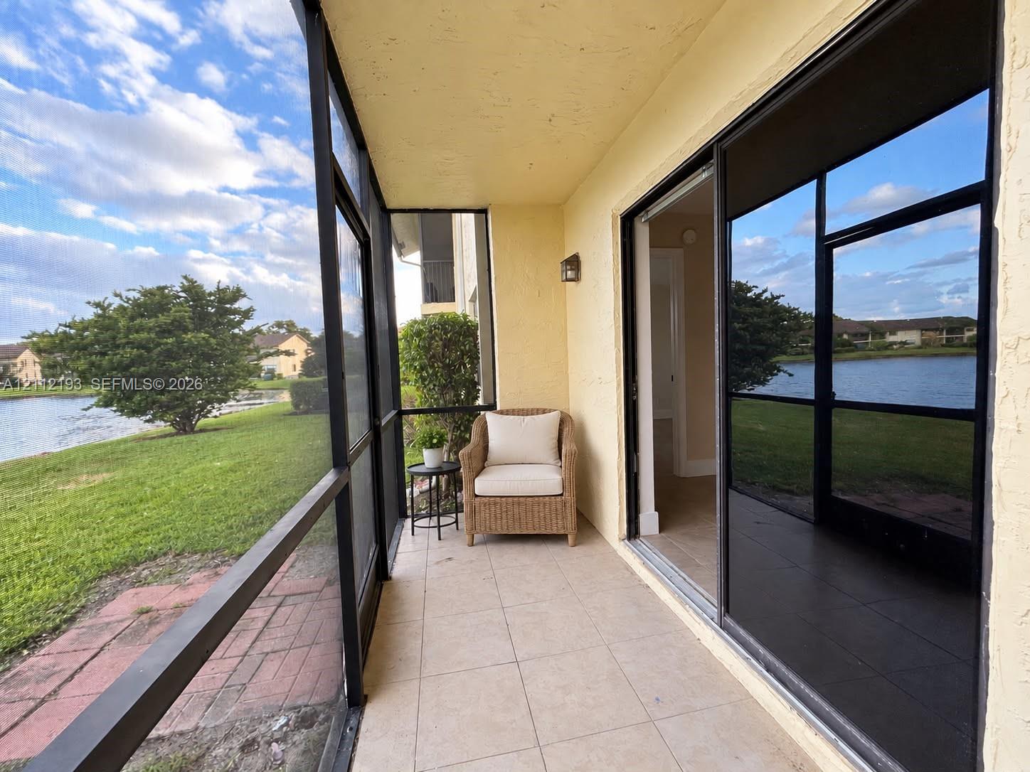 Screen-enclosed patio featuring tile flooring, metal framing, and sliding glass doors