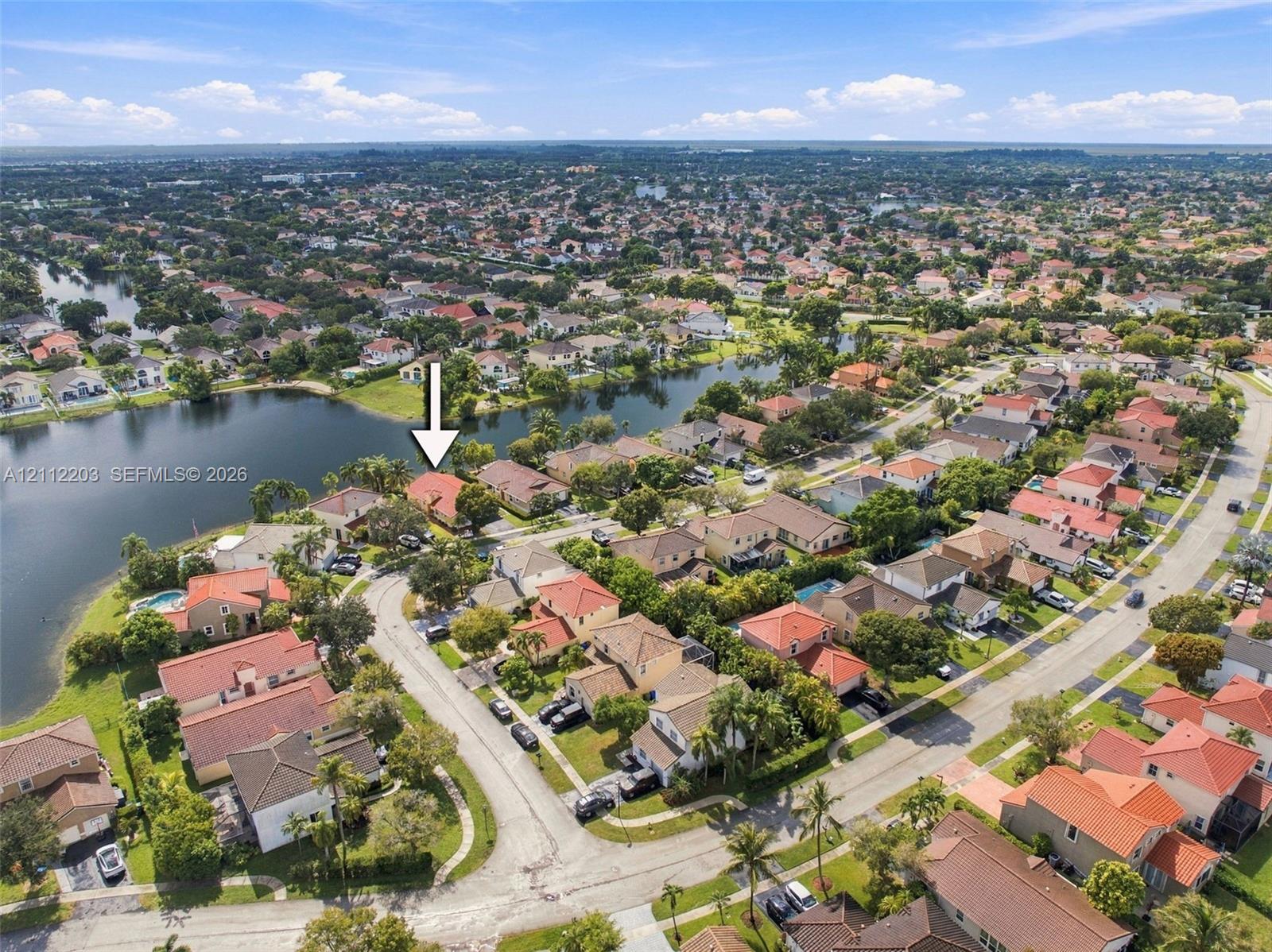 Aerial perspective featuring a waterfront residential property with a tiled roof, situated on a cul-de-sac lot