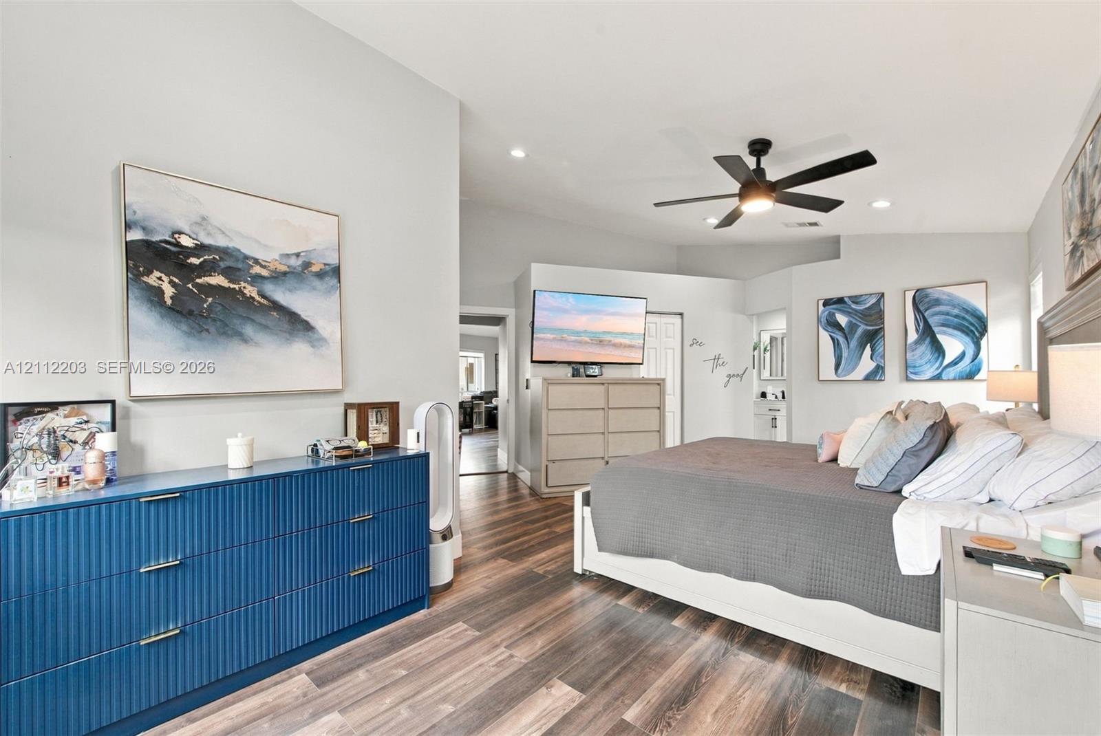 Vaulted ceilings, wood-finish flooring, and a ceiling fan with integrated lighting