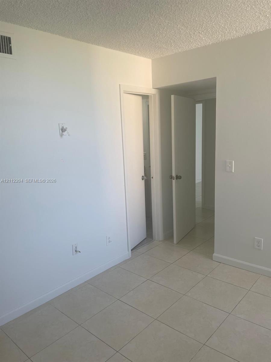 Interior room featuring neutral wall paint, tile flooring, and solid-core doors