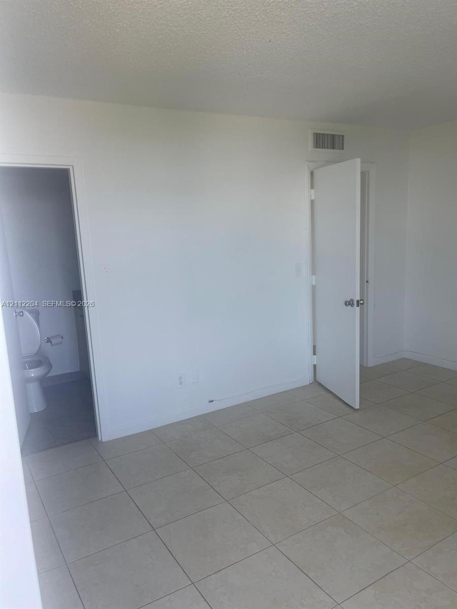 Neutral-toned tile flooring, solid-core interior doors, and clean-finished walls