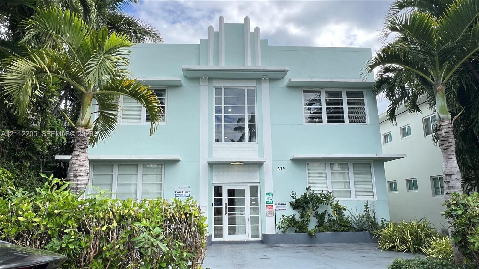 Art Deco exterior featuring a stepped roofline, multi-pane windows, horizontal structural bands, and a glass-paneled entry door Art Deco exterior featuring a stepped roofline, multi-pane windows, horizontal structural bands, and a glass-paneled entry door