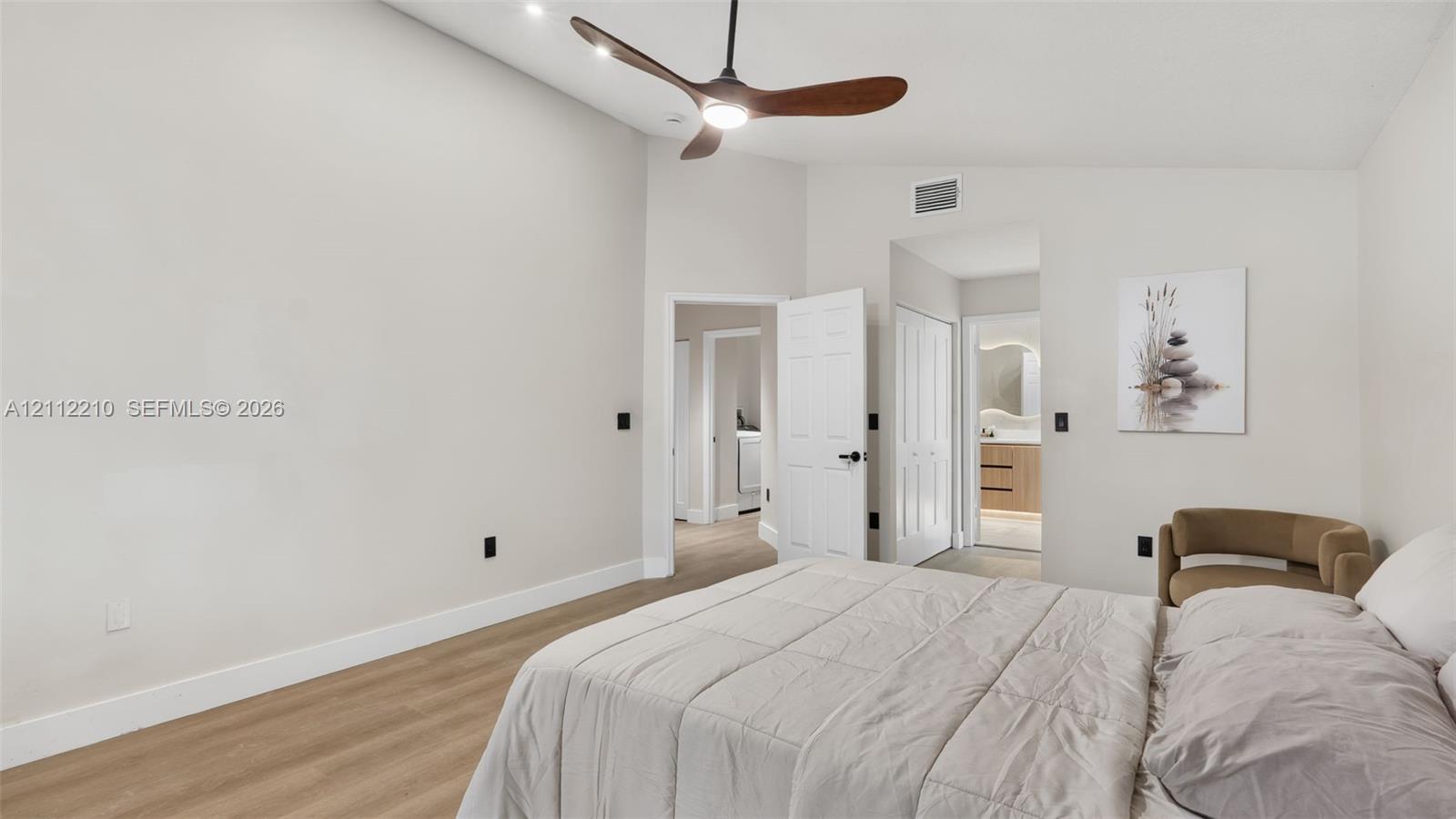 Vaulted ceilings, wood-finish flooring, and a modern ceiling fan with integrated lighting