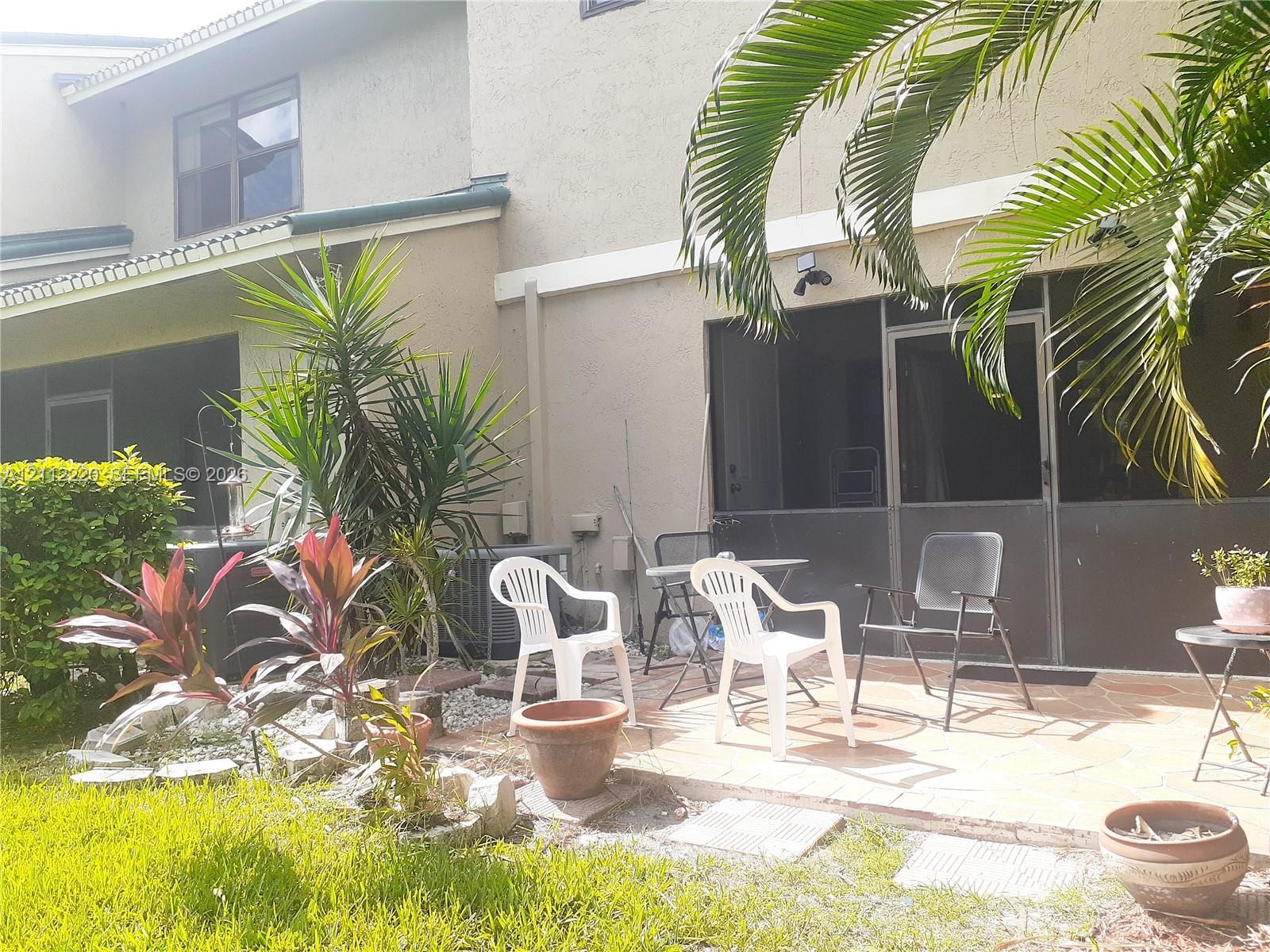 Screened-in patio with tiled flooring and stone-accented landscaping
