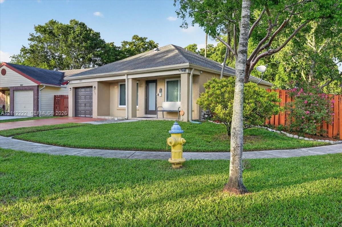 Single-story residence featuring a covered front porch, stucco exterior, hip roof, and an attached garage with a paved driveway