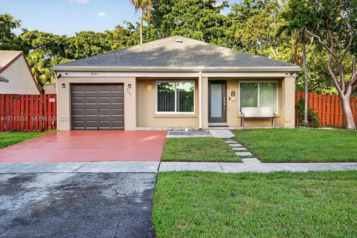 Single-story residence featuring a shingled roof, attached one-car garage, painted stucco exterior, glass-panel entry door, and perimeter privacy fencing Single-story residence featuring a shingled roof, attached one-car garage, painted stucco exterior, glass-panel entry door, and perimeter privacy fencing