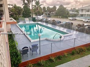 In-ground swimming pool featuring a concrete deck and metal perimeter fencing