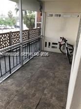 Screened-in balcony featuring tile flooring and decorative lattice railing