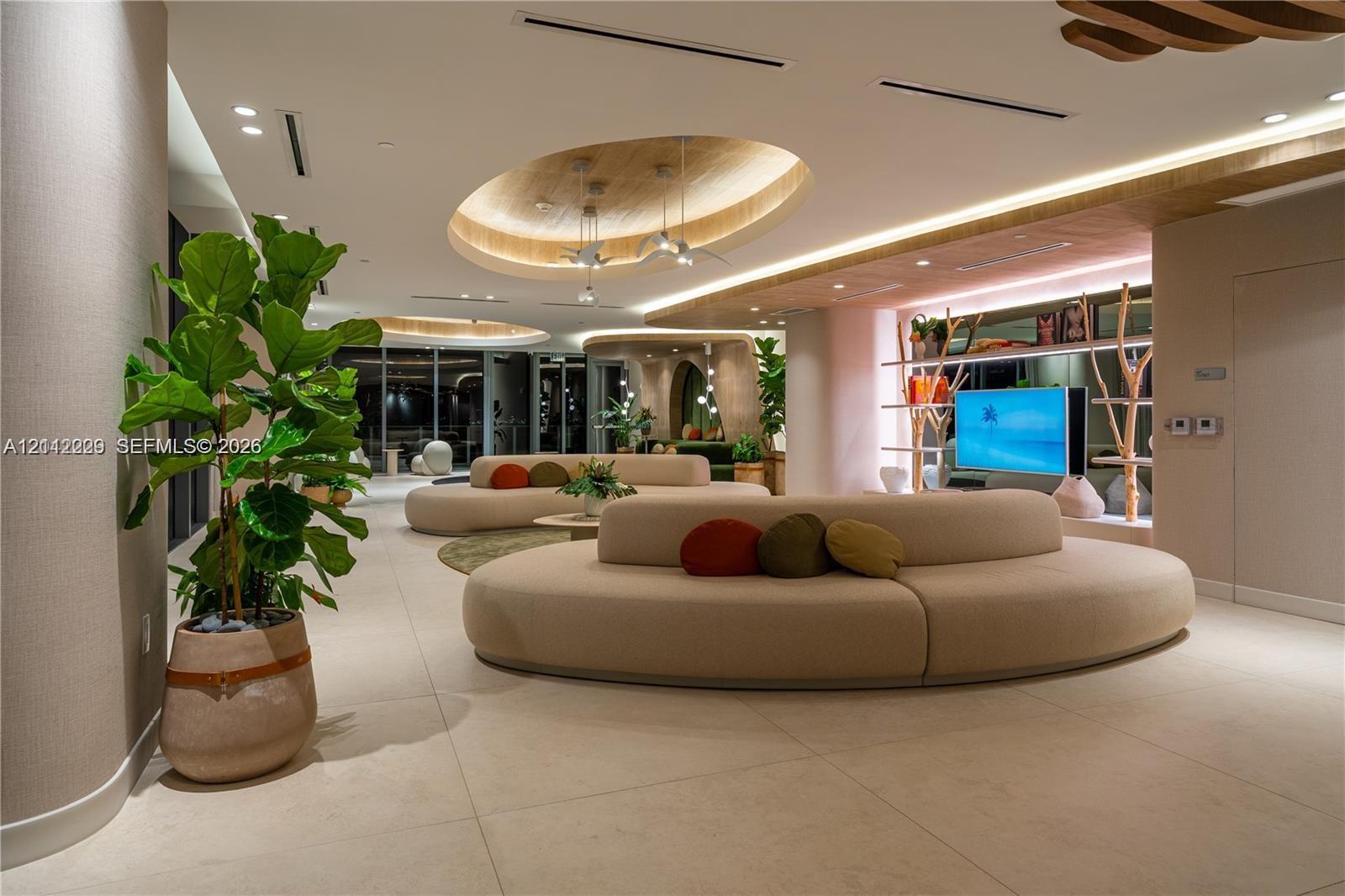 Large-format tile flooring, recessed oval tray ceilings with integrated ambient lighting, and built-in display shelving