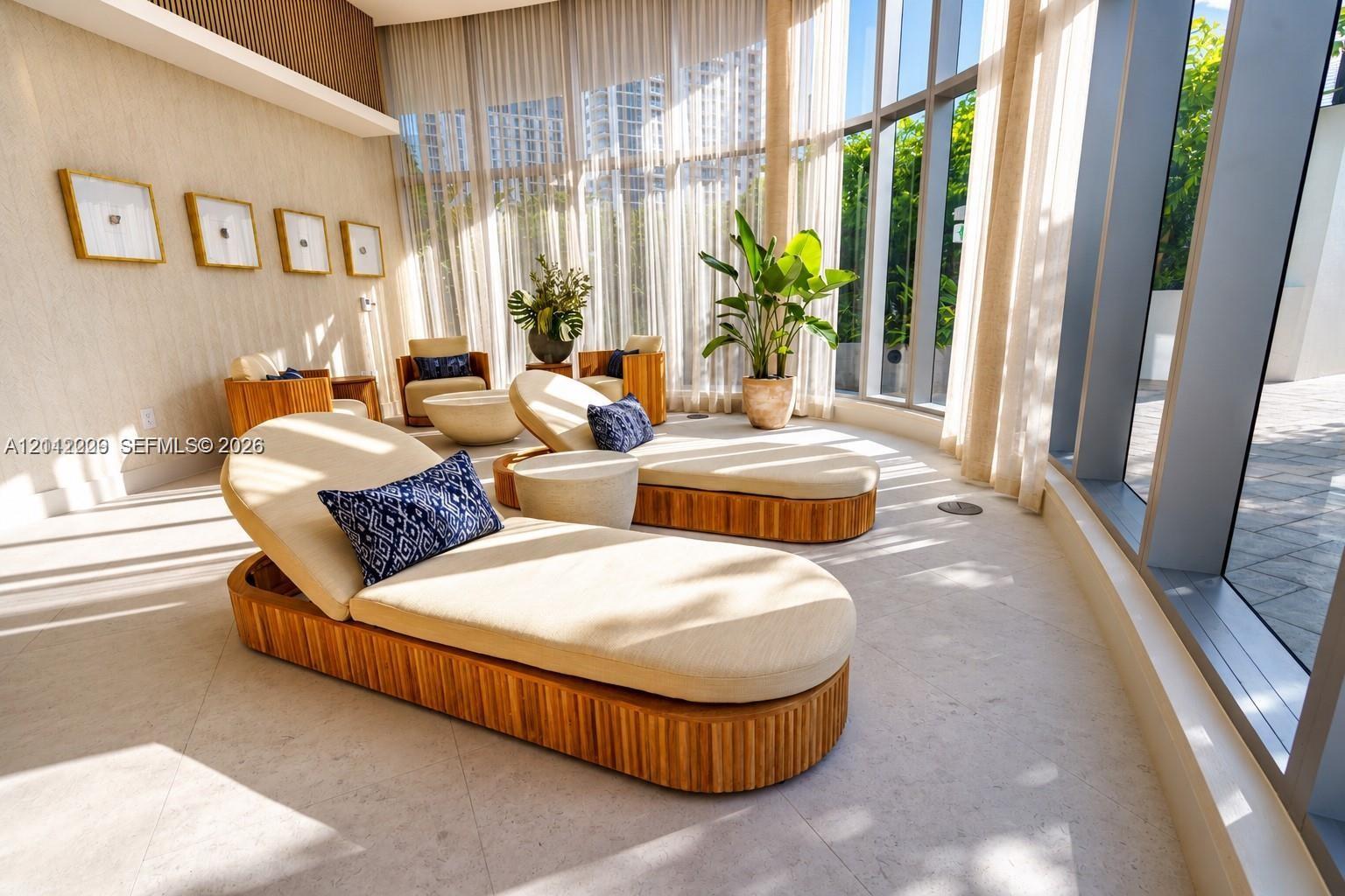 Floor-to-ceiling windows, stone tile flooring, and textured wall coverings