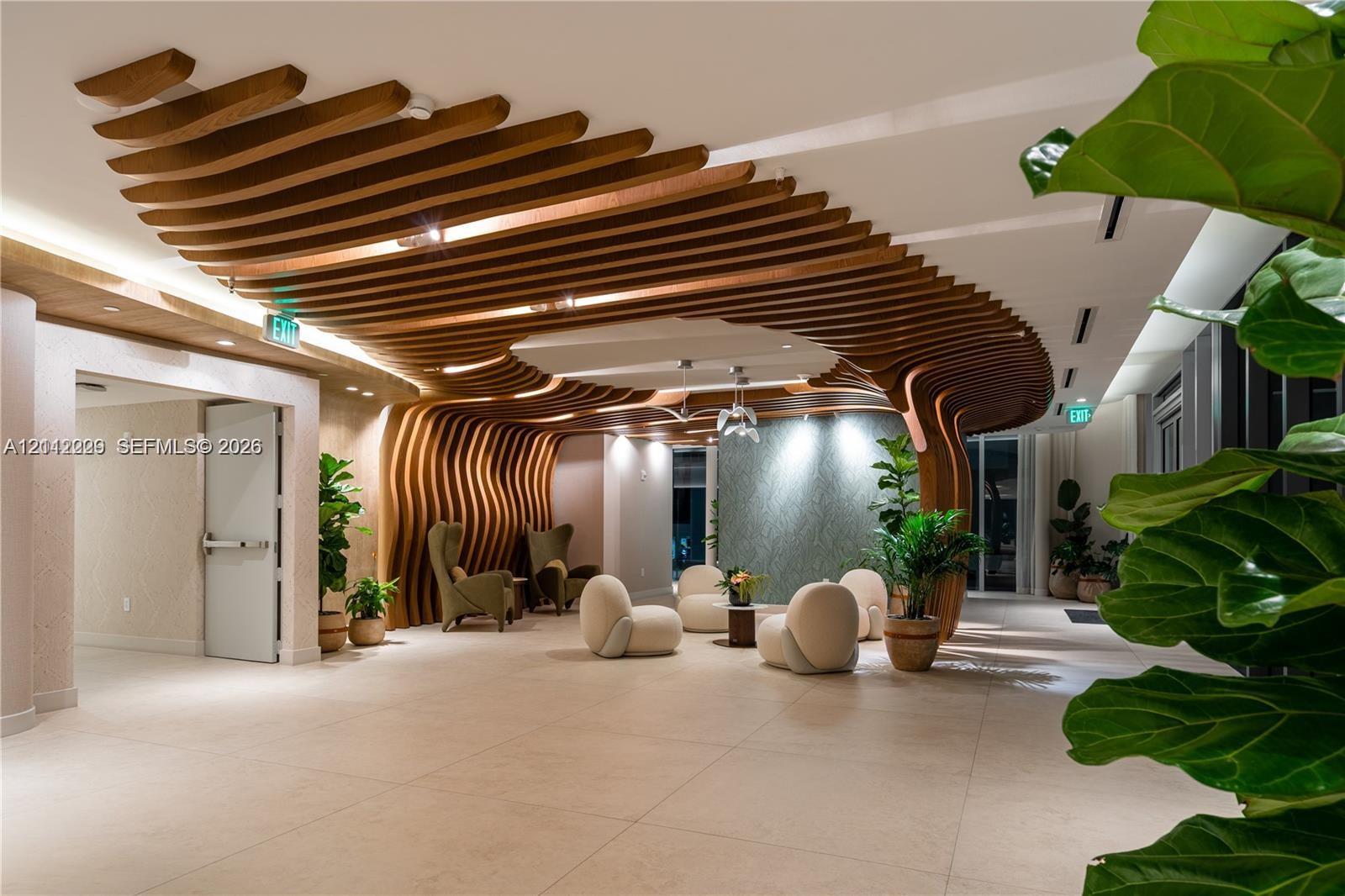 Architectural ceiling feature composed of organic, suspended wooden slats, large-format tile flooring, textured accent wall, and recessed perimeter lighting