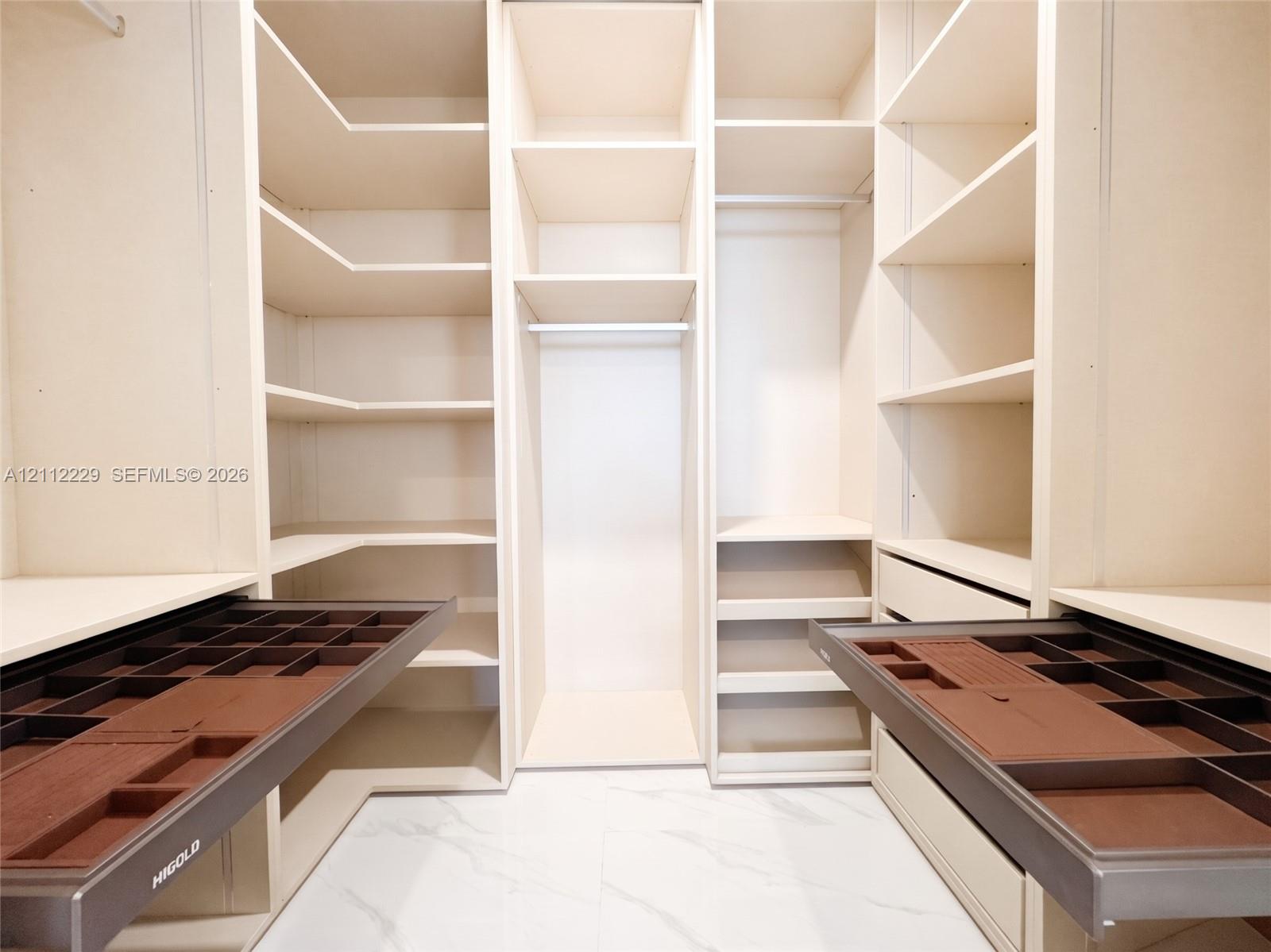 Customized closet storage featuring floor-to-ceiling cabinetry, adjustable shelving, hanging rods, and integrated pull-out velvet-lined jewelry organizer drawers