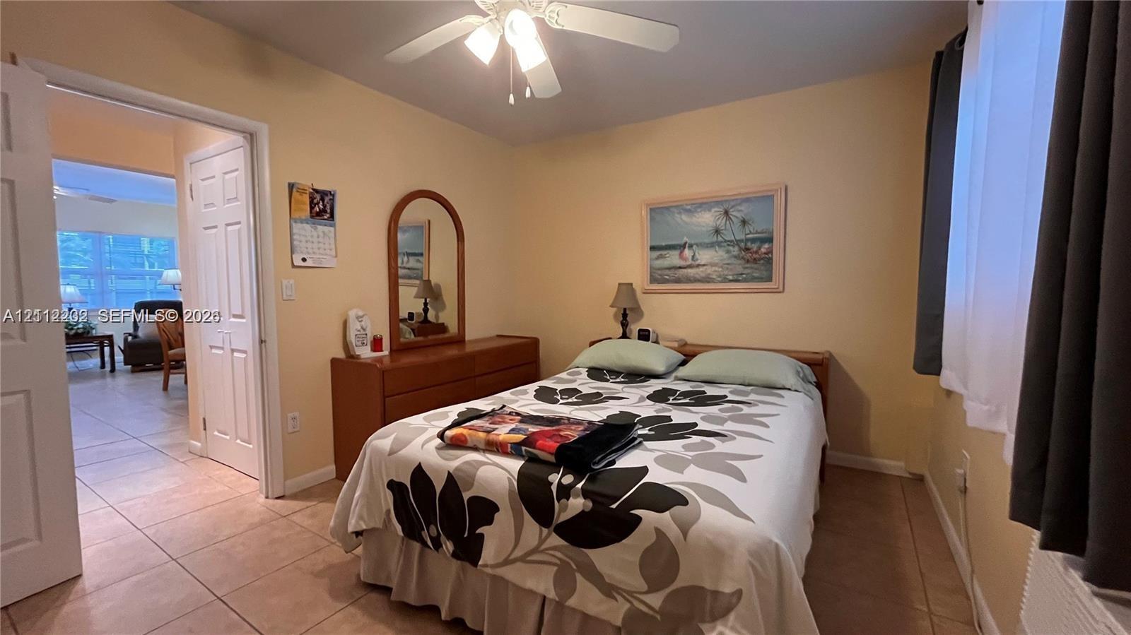 Ceramic tile flooring, white-panel interior doors, and a ceiling-mounted light fixture with fan