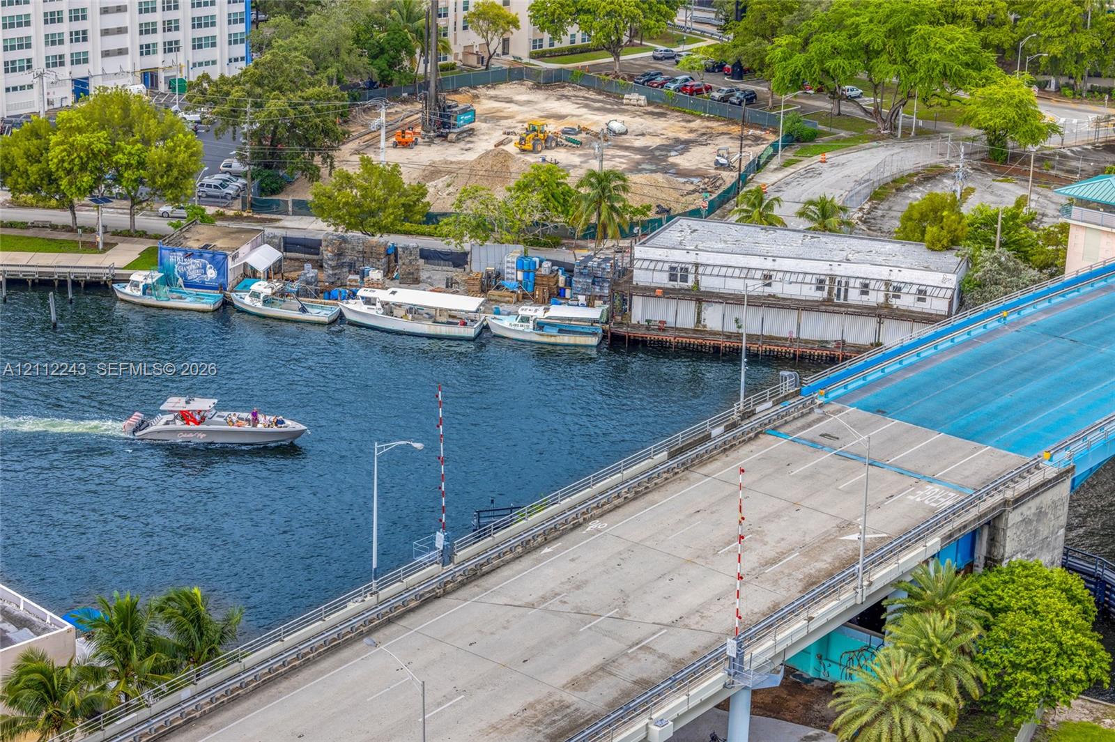 Aerial perspective featuring a waterfront location with active canal access and mature palm tree landscaping