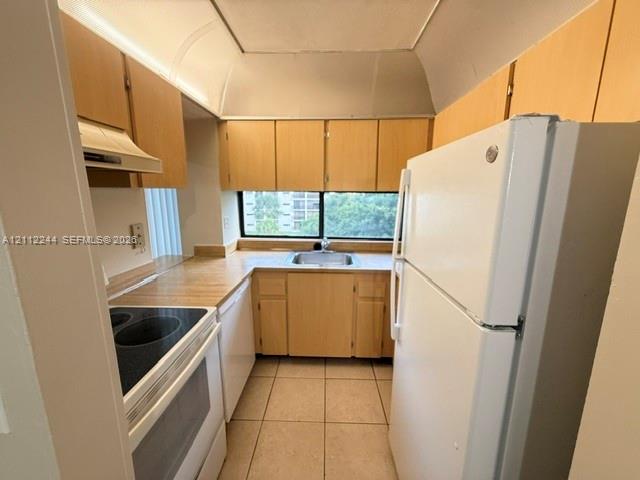 Kitchen featuring light-finish cabinetry, solid-surface countertops, tile flooring, and a window above the undermount stainless steel sink