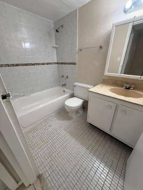 Bathroom featuring a vanity with a stone-top integrated sink, a full-width medicine cabinet, a shower and tub combination with decorative tile inlay, and mosaic floor tiling