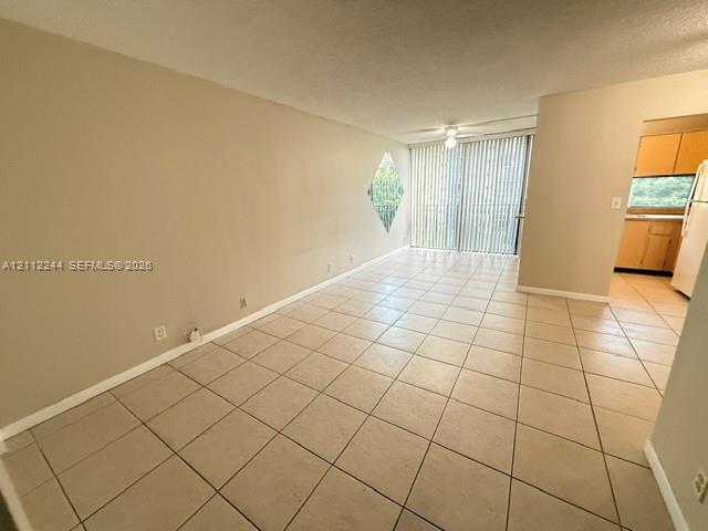 Neutral tile flooring, diamond-shaped accent window, and sliding glass door with vertical blinds Neutral tile flooring, diamond-shaped accent window, and sliding glass door with vertical blinds