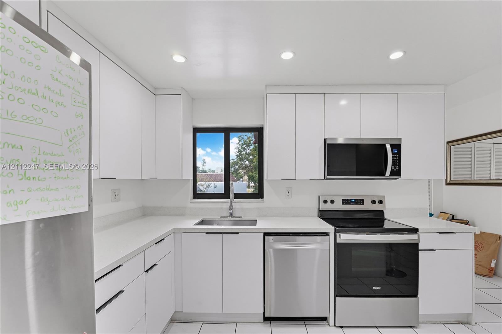 Kitchen featuring white slab-front cabinetry, stone-finish countertops, stainless steel appliances, and recessed lighting