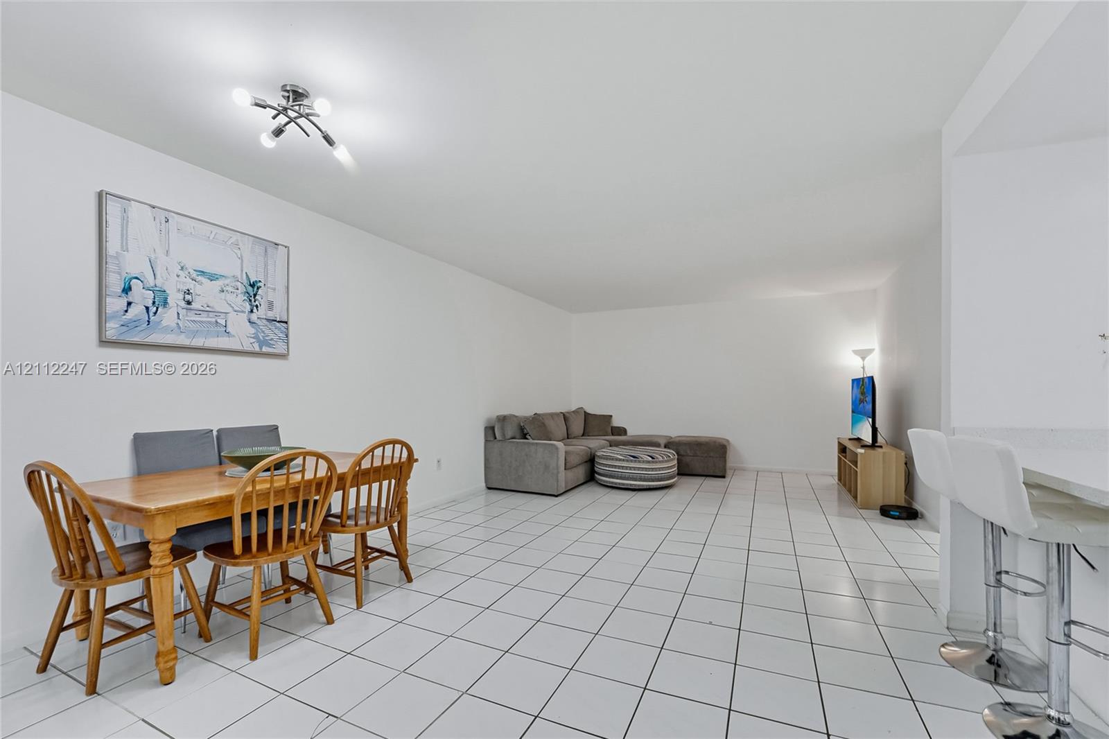 Open-concept interior featuring white ceramic tile flooring and a multi-bulb contemporary ceiling fixture