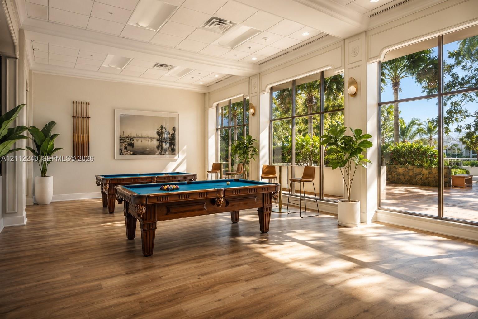 Common area featuring wood-finish flooring, floor-to-ceiling windows, and recessed ceiling panels