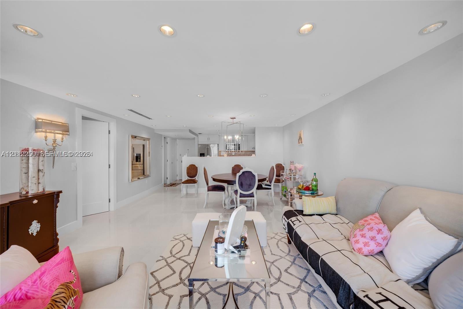 Open-concept interior featuring high-gloss flooring, recessed lighting, and a modern light fixture