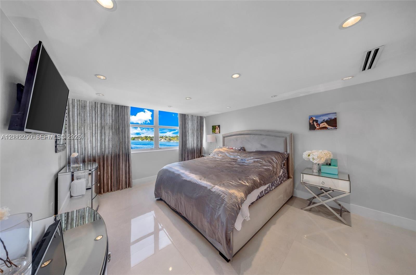 Large-format windows with water scenery, recessed ceiling lighting, and polished stone-finish flooring