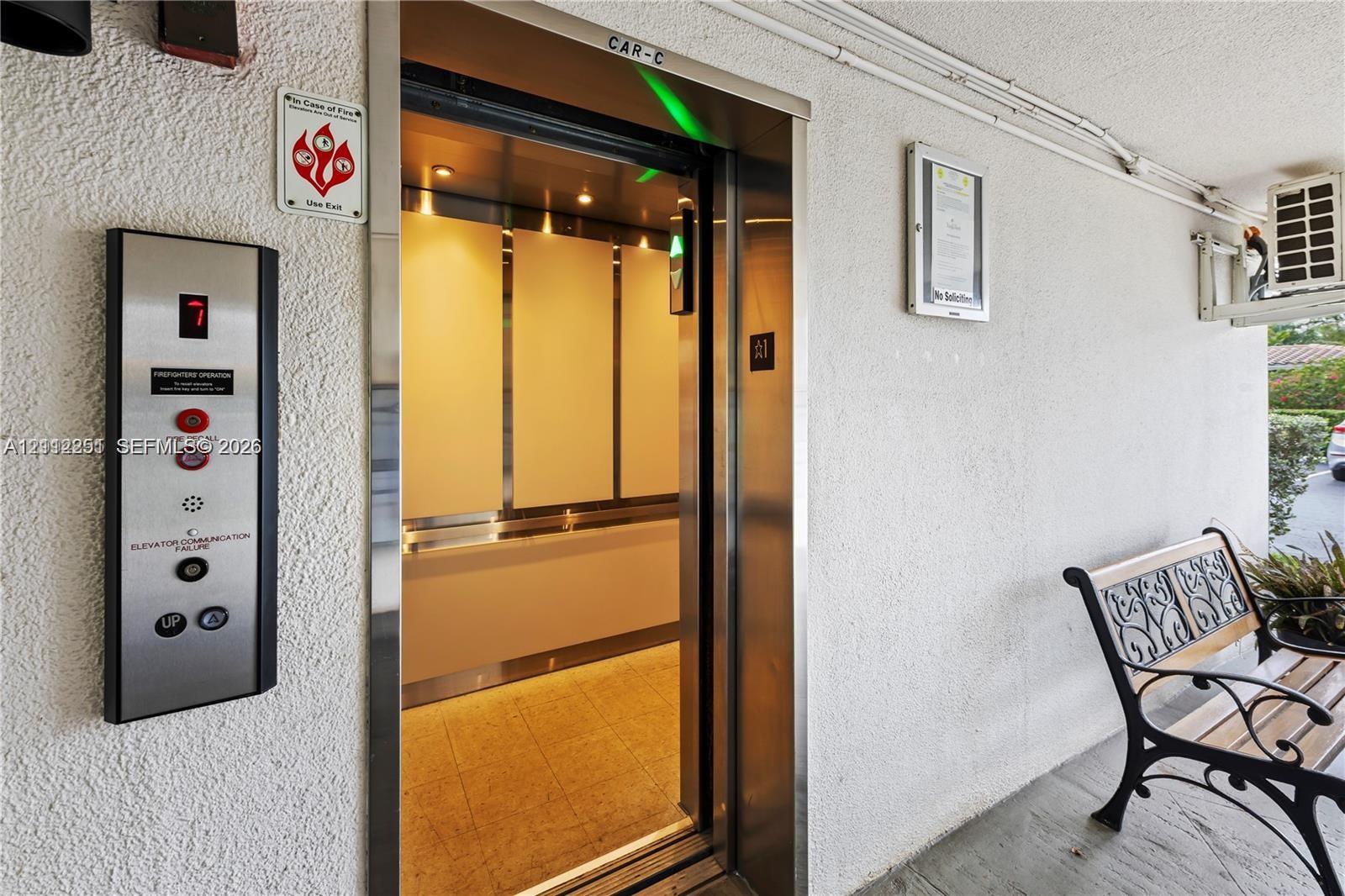 Elevator access featuring a brushed metal control panel and high-contrast interior paneling