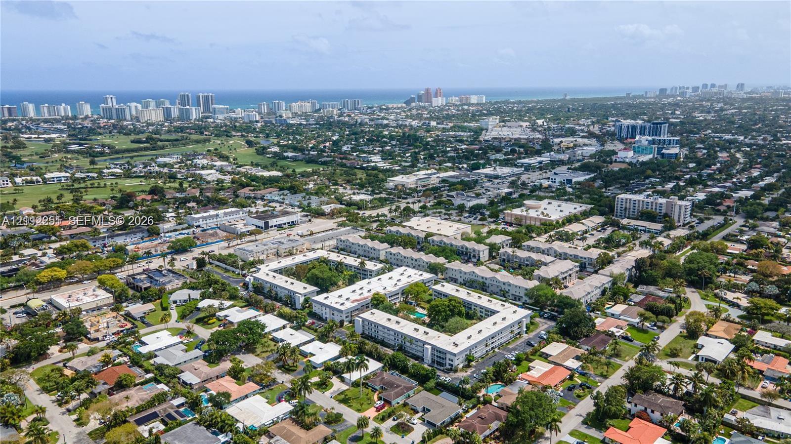Aerial perspective featuring proximity to the Atlantic coastline, expansive urban surroundings, and mature palm tree canopy