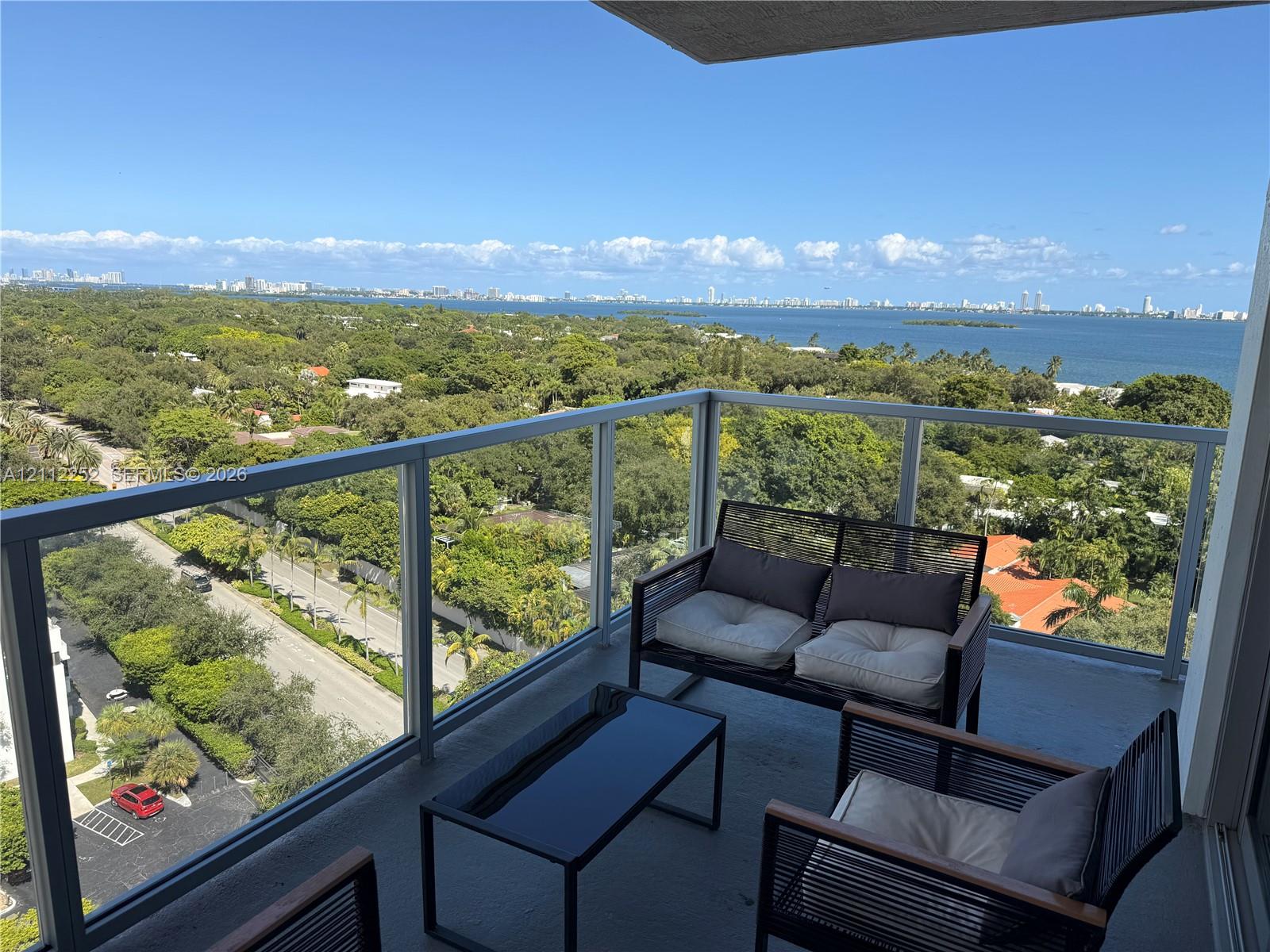 Private balcony featuring glass panel railings and expansive overhead coverage Private balcony featuring glass panel railings and expansive overhead coverage