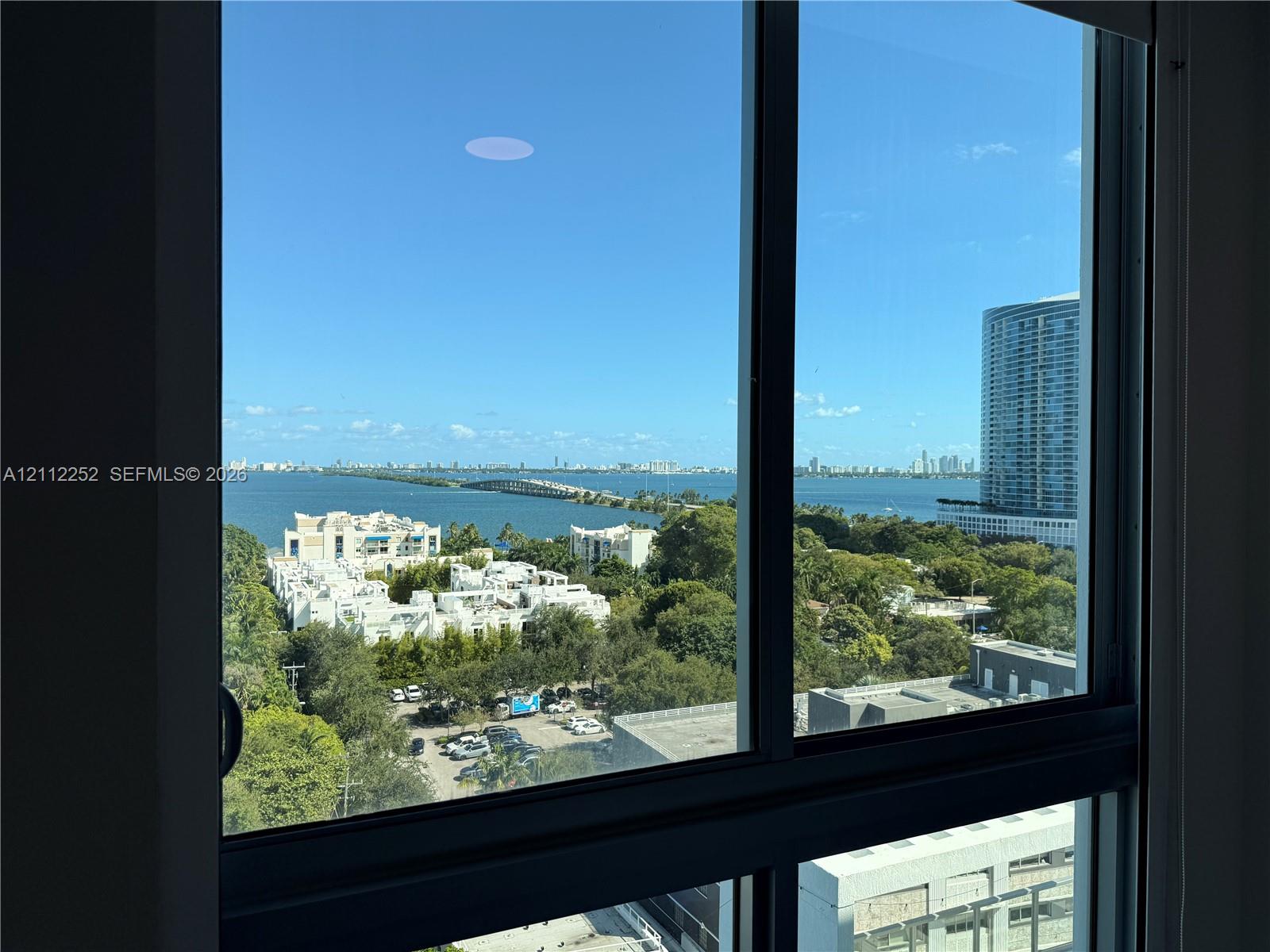 Floor-to-ceiling windows with expansive water and metropolitan skyline backdrop