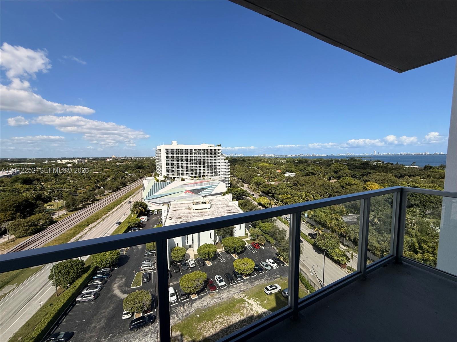 Covered balcony featuring glass railing and concrete flooring