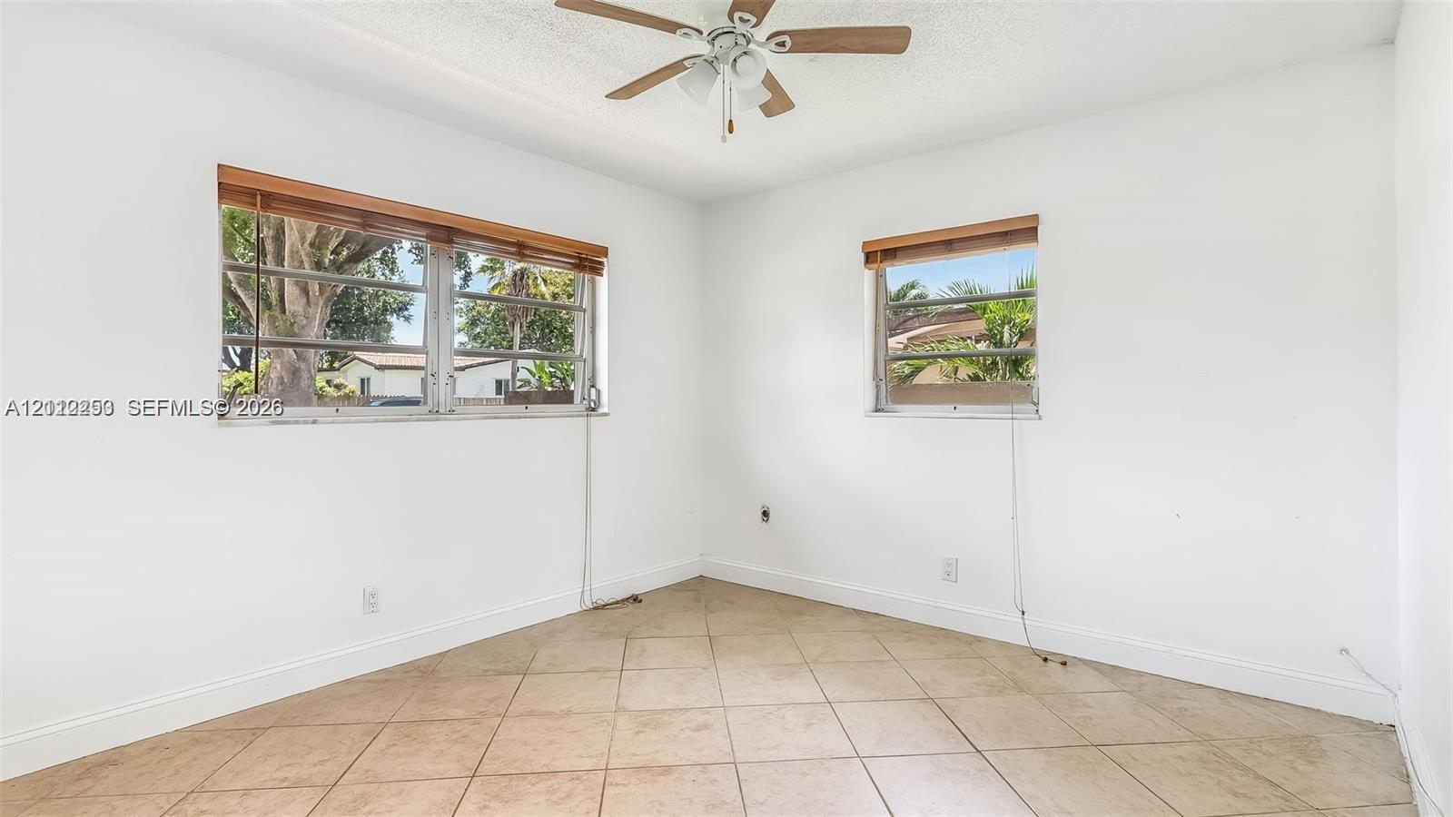 Neutral wall finish, ceramic tile flooring, ceiling fan with light fixture, and horizontal window treatments